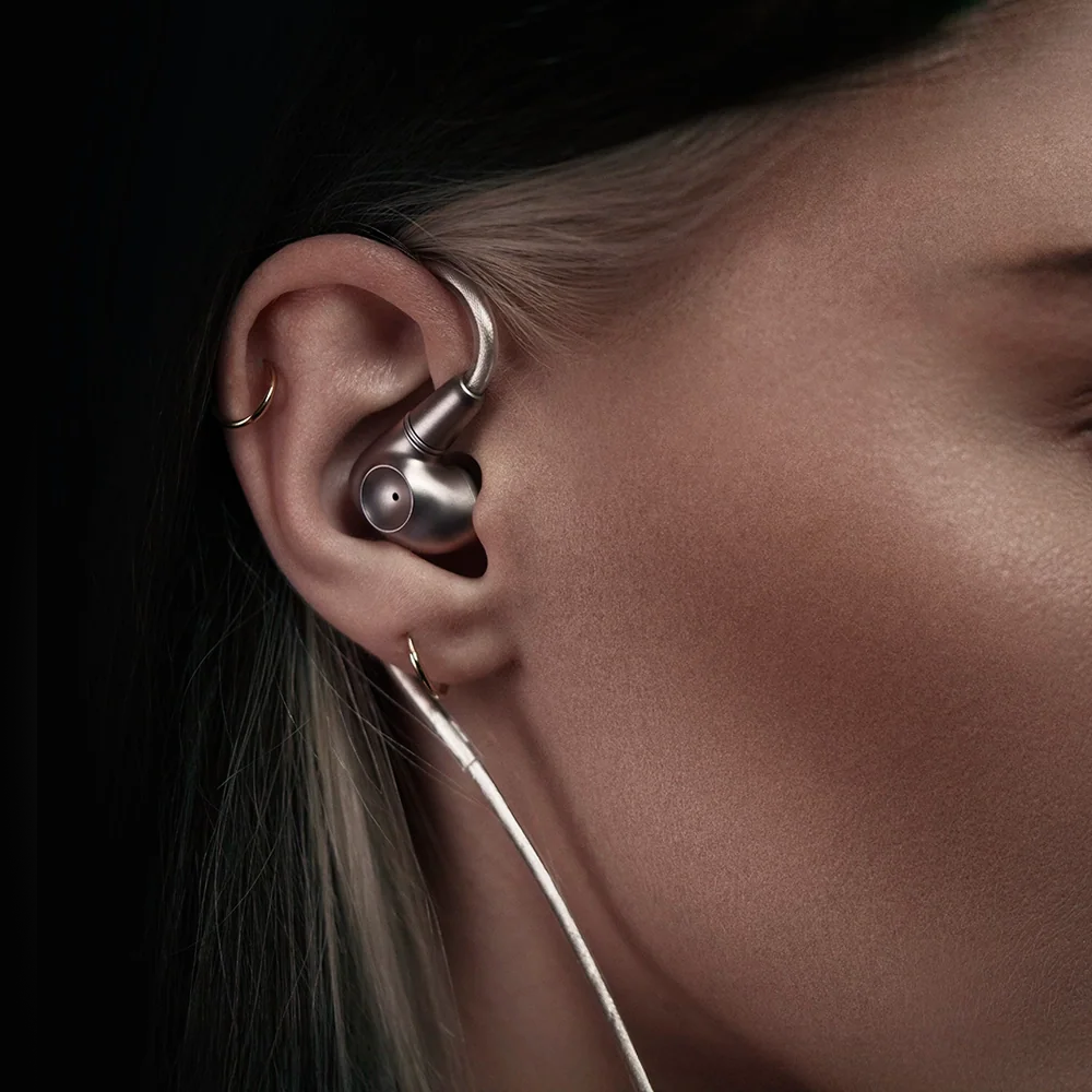 Meze Audio Astru wired in-ear headphones with black earbuds and inline microphone on a white background.