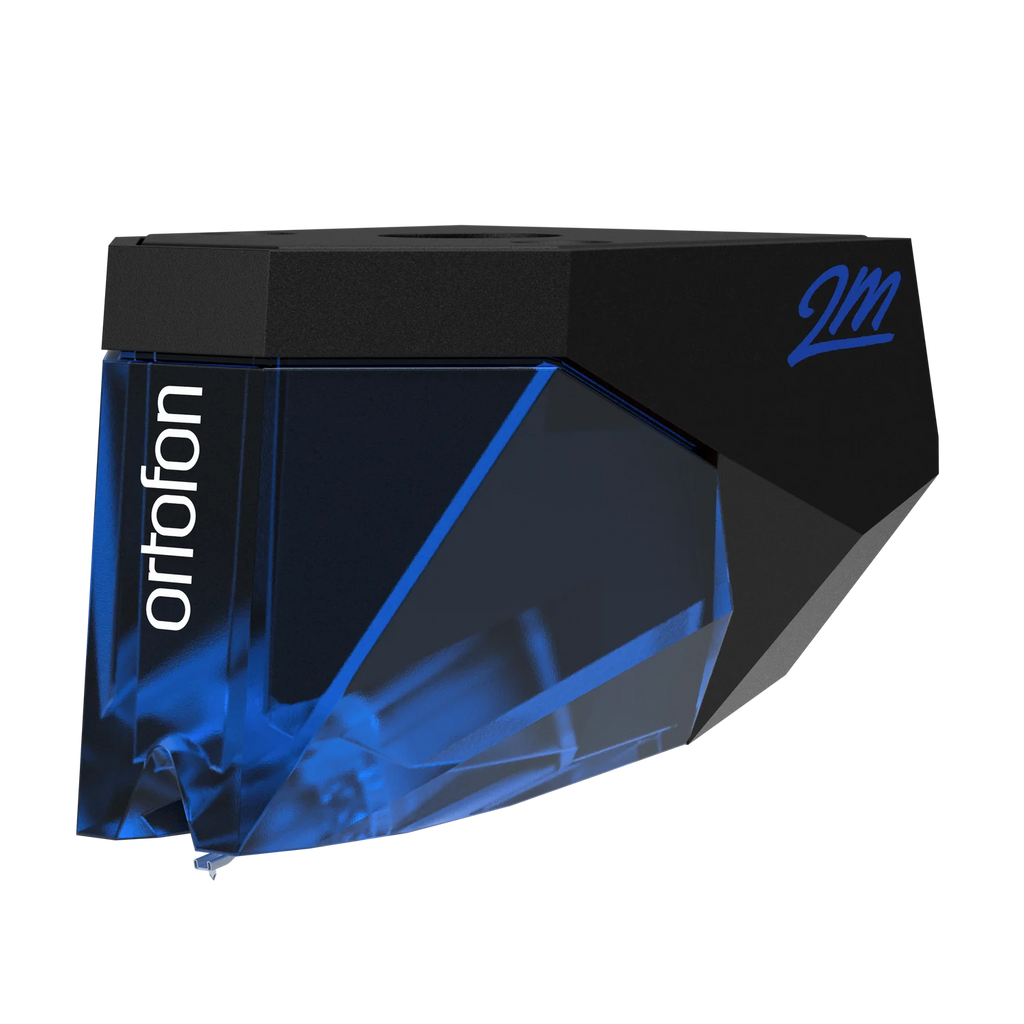 Ortofon 2M Blue turntable cartridge stylus tilted left, showing the detailed stylus tip and branding on the cartridge body.