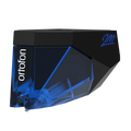 Ortofon 2M Blue turntable cartridge stylus tilted left, showing the detailed stylus tip and branding on the cartridge body.