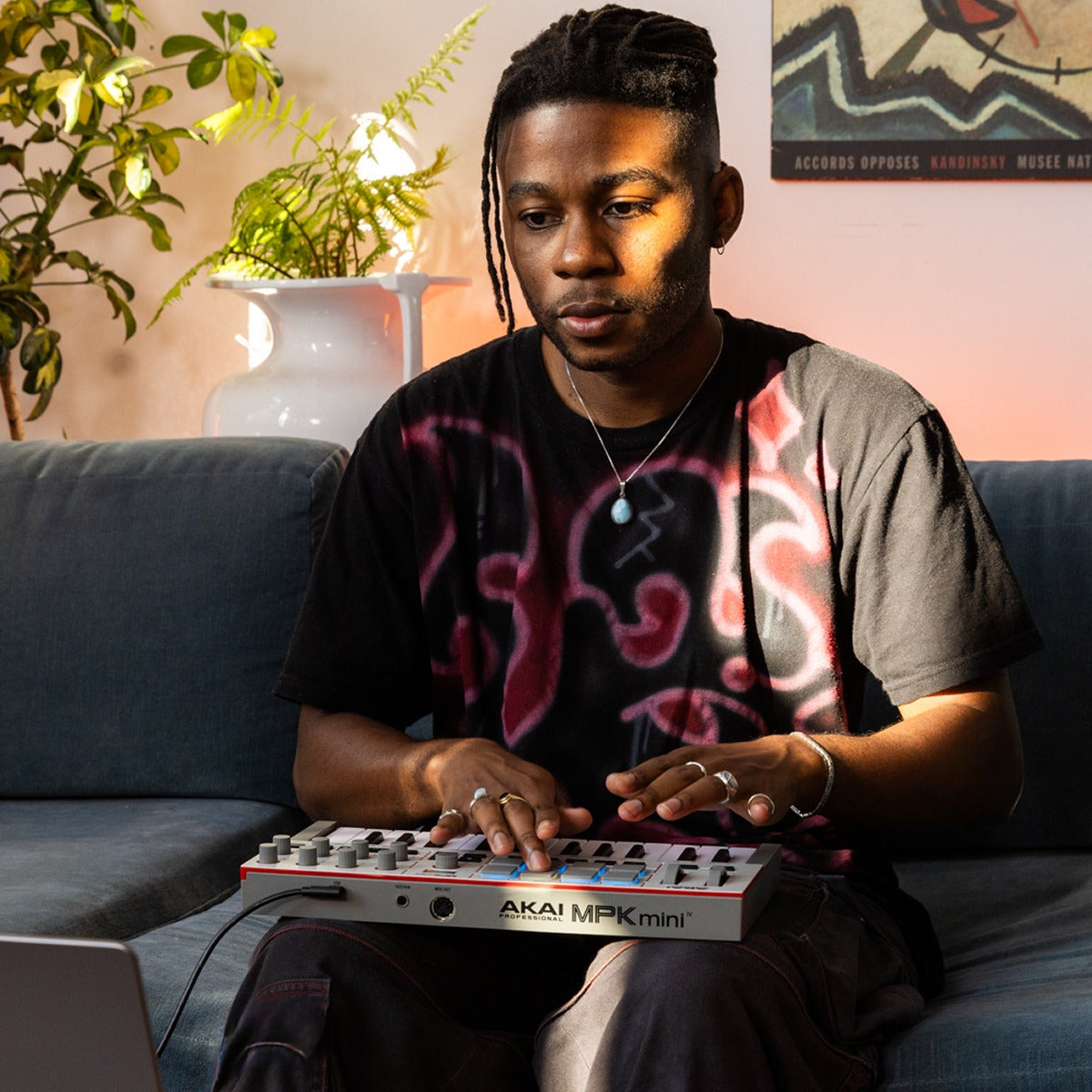 Akai Professional MPK Mini IV MIDI keyboard with compact design, 25 keys, drum pads, and control knobs for music production.