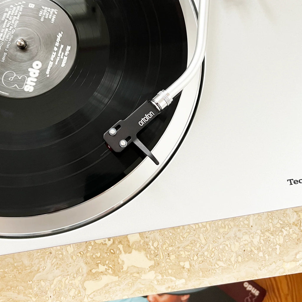 Ortofon SH-4 headshell in black attached to a turntable for vinyl record playback, showcasing cartridge connection and tonearm compatibility.