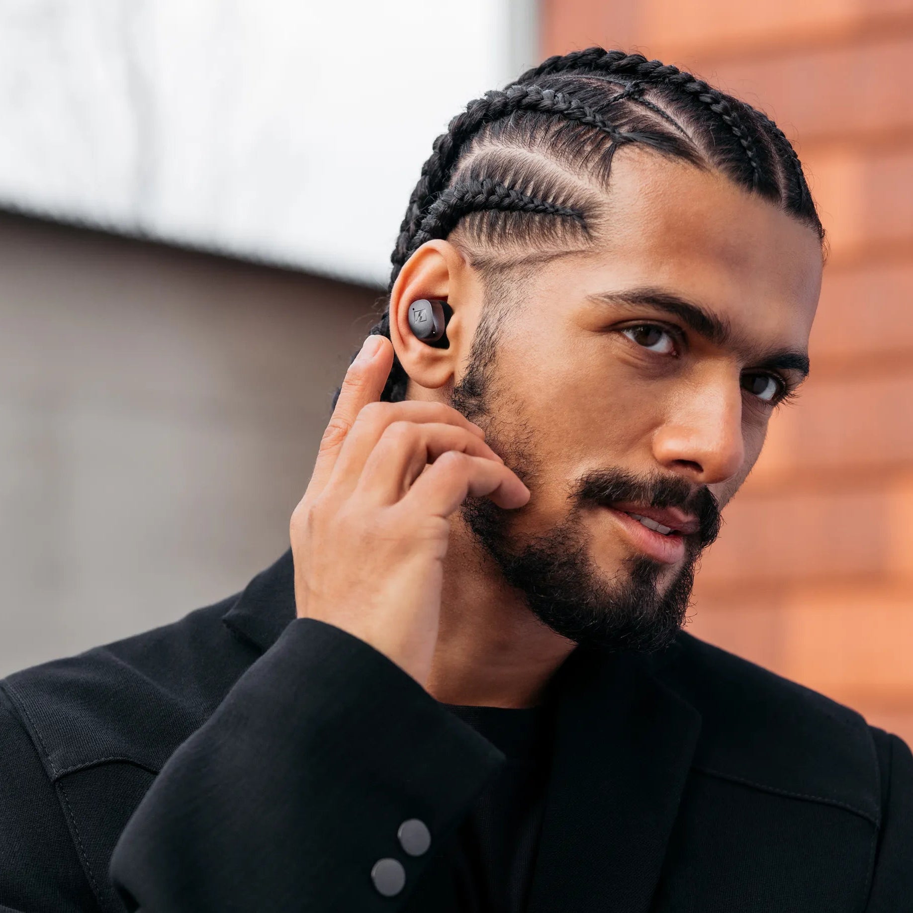 Sennheiser Momentum True Wireless 4 black in-ear headphones displayed in a lifestyle portrait.