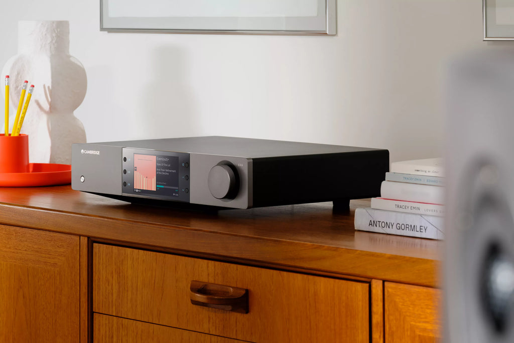 Cambridge Audio EXN100 music streamer showing front and side view with sleek black design and control buttons.