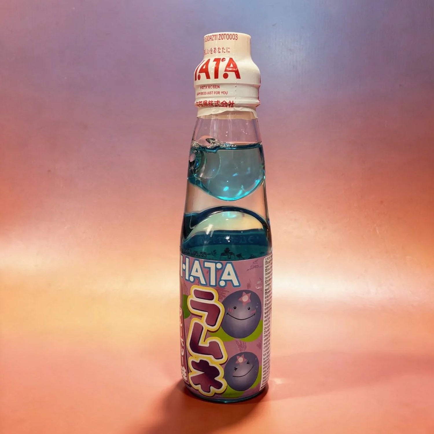 Bottle of Hata beverage with blue liquid on a gradient background