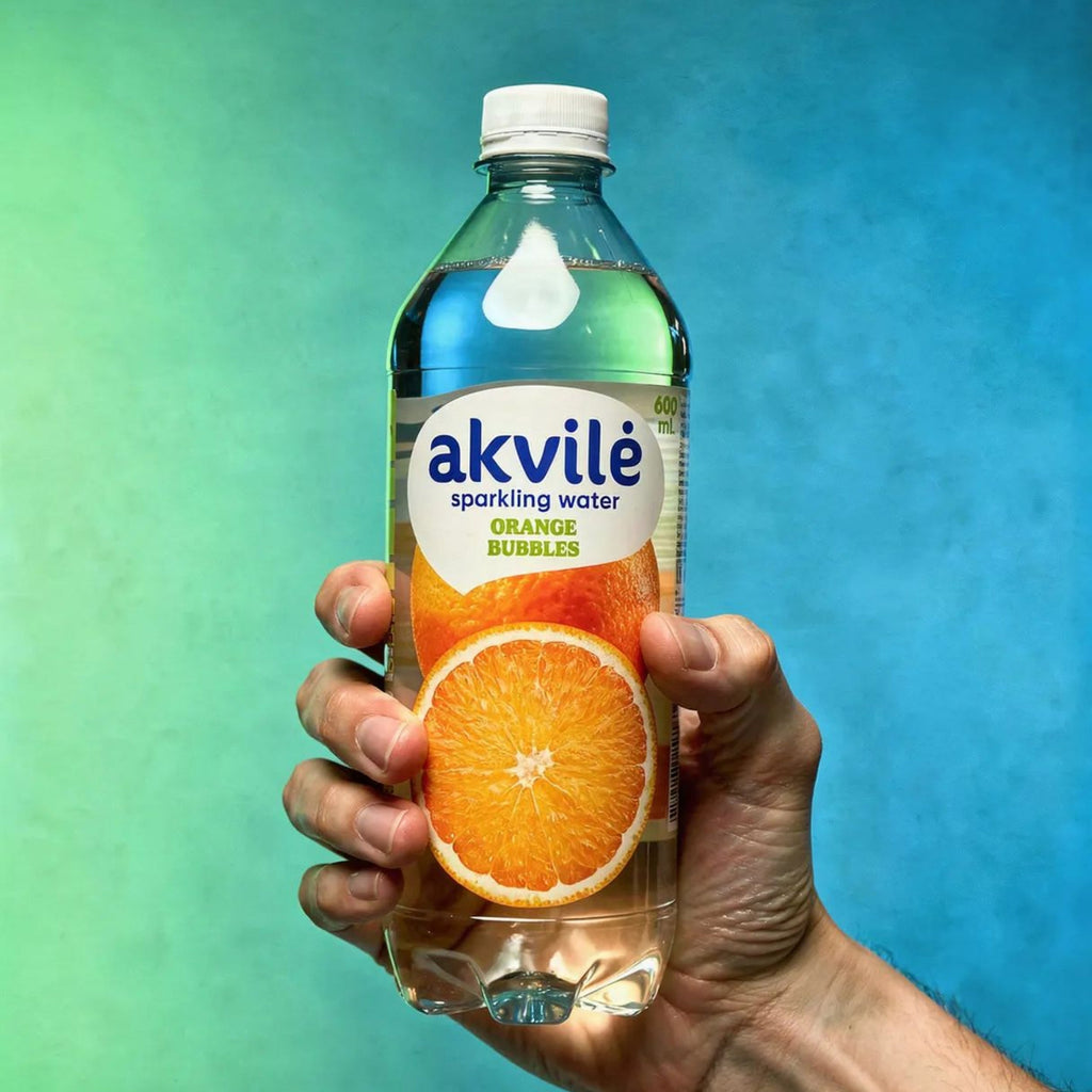 Akvilė Orange lightly sparkling water in a 600ml bottle with a vibrant orange label and clear liquid inside.
