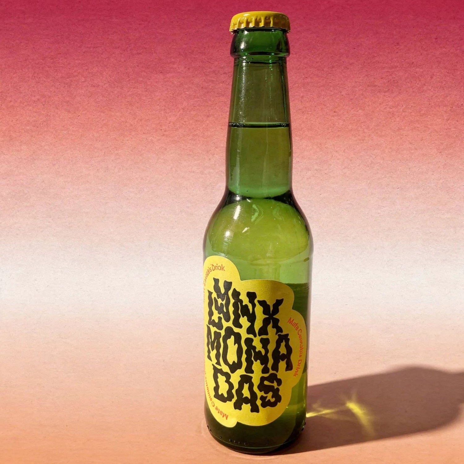 Green bottle with a yellow label on a gradient pink to orange background