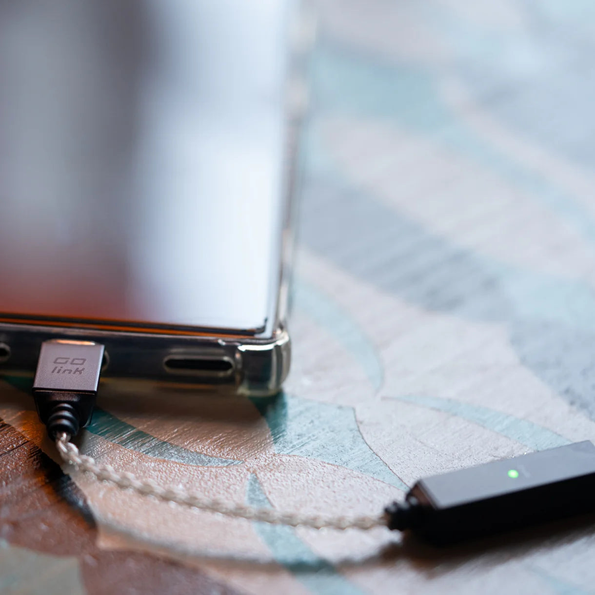 iFi Audio GO link 2 headphone amplifier and DAC, compact silver device with multiple input options and control knobs.