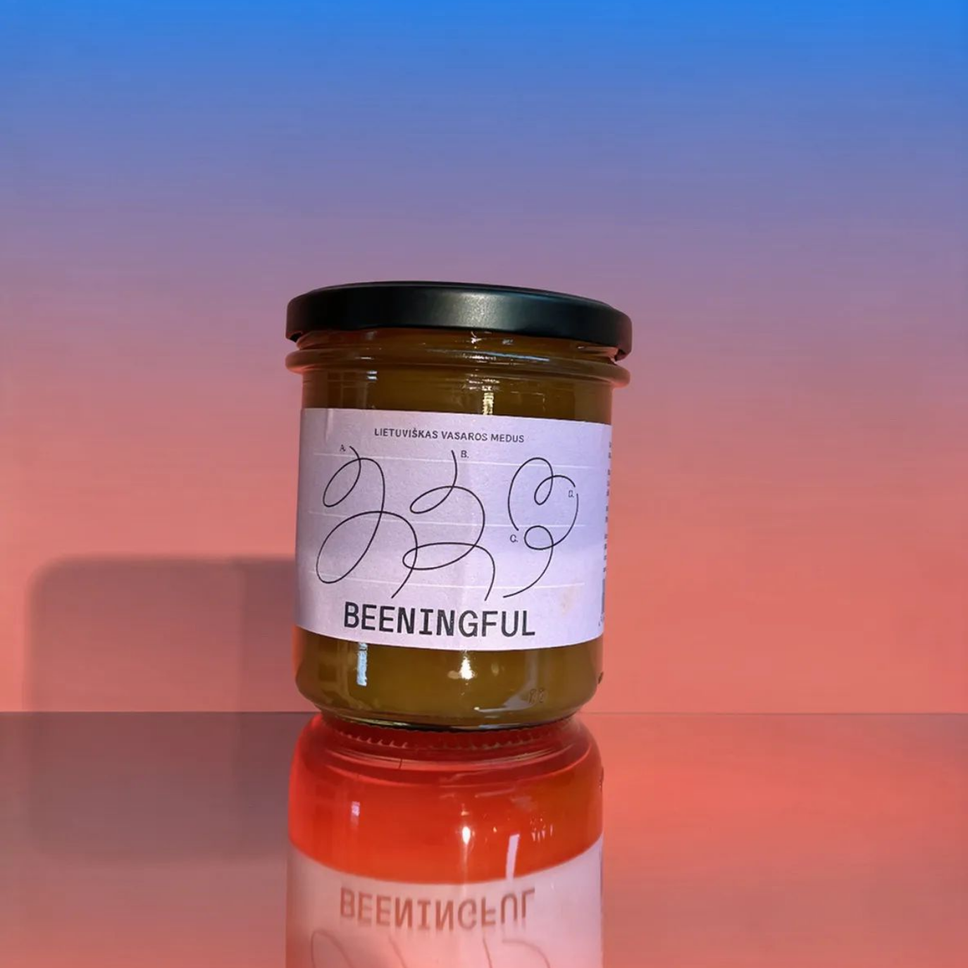 Jar of 'BEENINGFUL' on a reflective surface with a gradient background