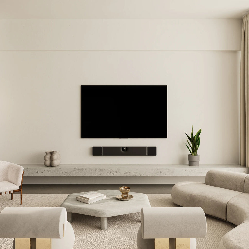 Devialet Dione soundbar mounted on wall in a modern living room, showcasing sleek black design and premium audio setup.