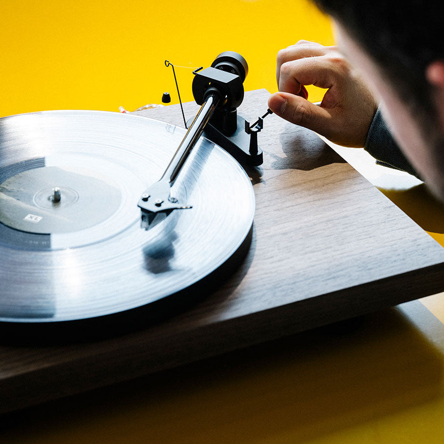 Pro-Ject Debut EVO 2 turntable with sleek design, tonearm, and platter, showcasing its modern audio equipment features.