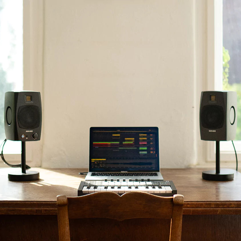 Adam Audio D3V active nearfield monitor speakers shown on a desktop setup with audio equipment and studio environment.