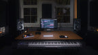 Adam Audio S3V studio monitor placed on a desk in a professional music studio setup.