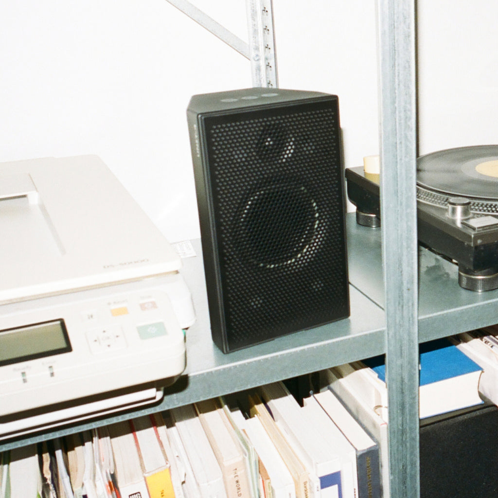 AIAIAI UNIT-4 MKII, black speaker on a shelf next to a turntable