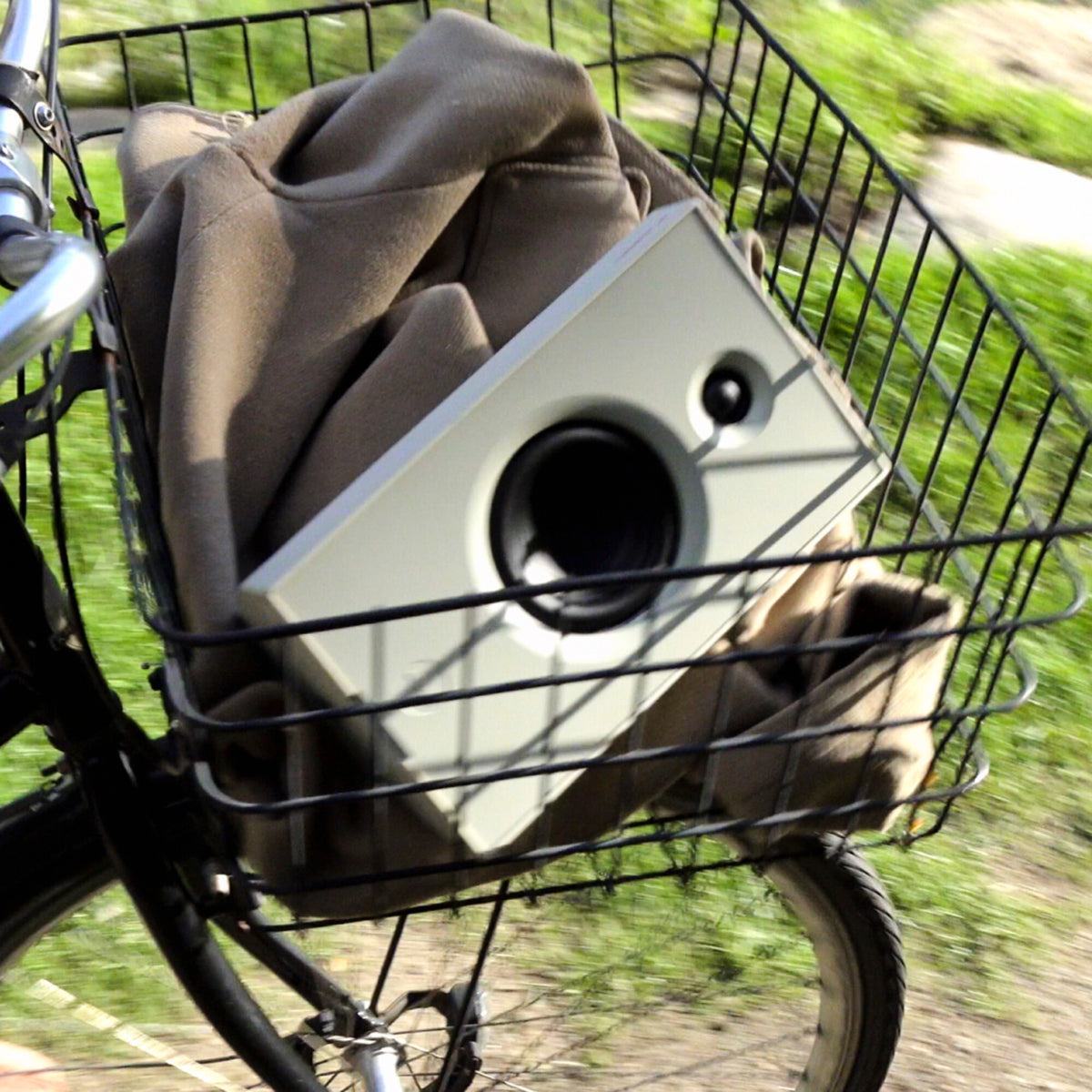 AIAIAI UNIT-4 MKII, white speaker in a bicycle basket