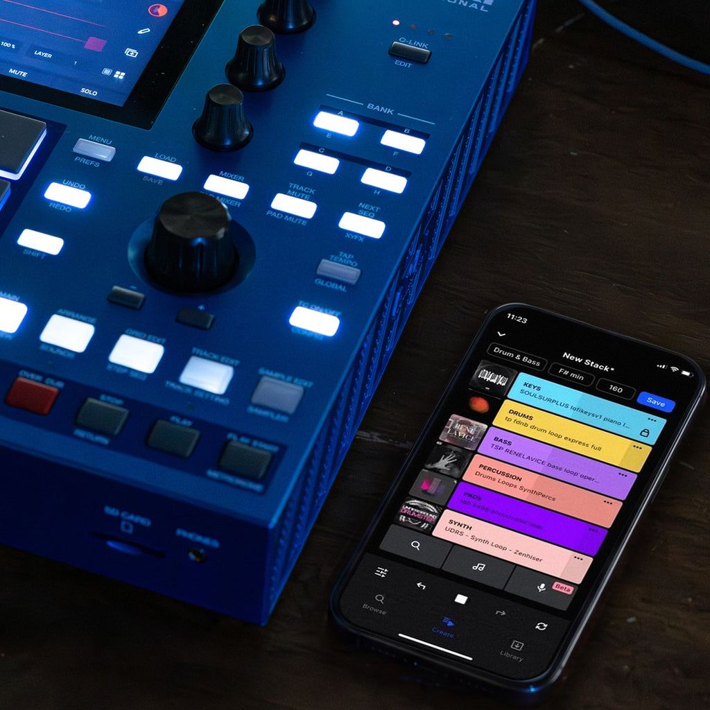 Akai Professional MPC One G2 on a desk beside a phone running the MPC app