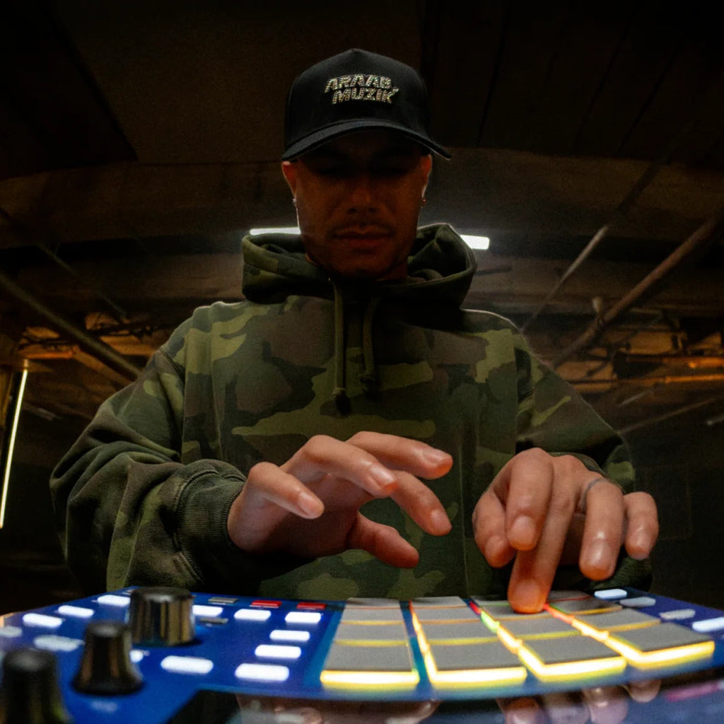 Akai Professional MPC One G2 played in a studio, glowing pads in low light