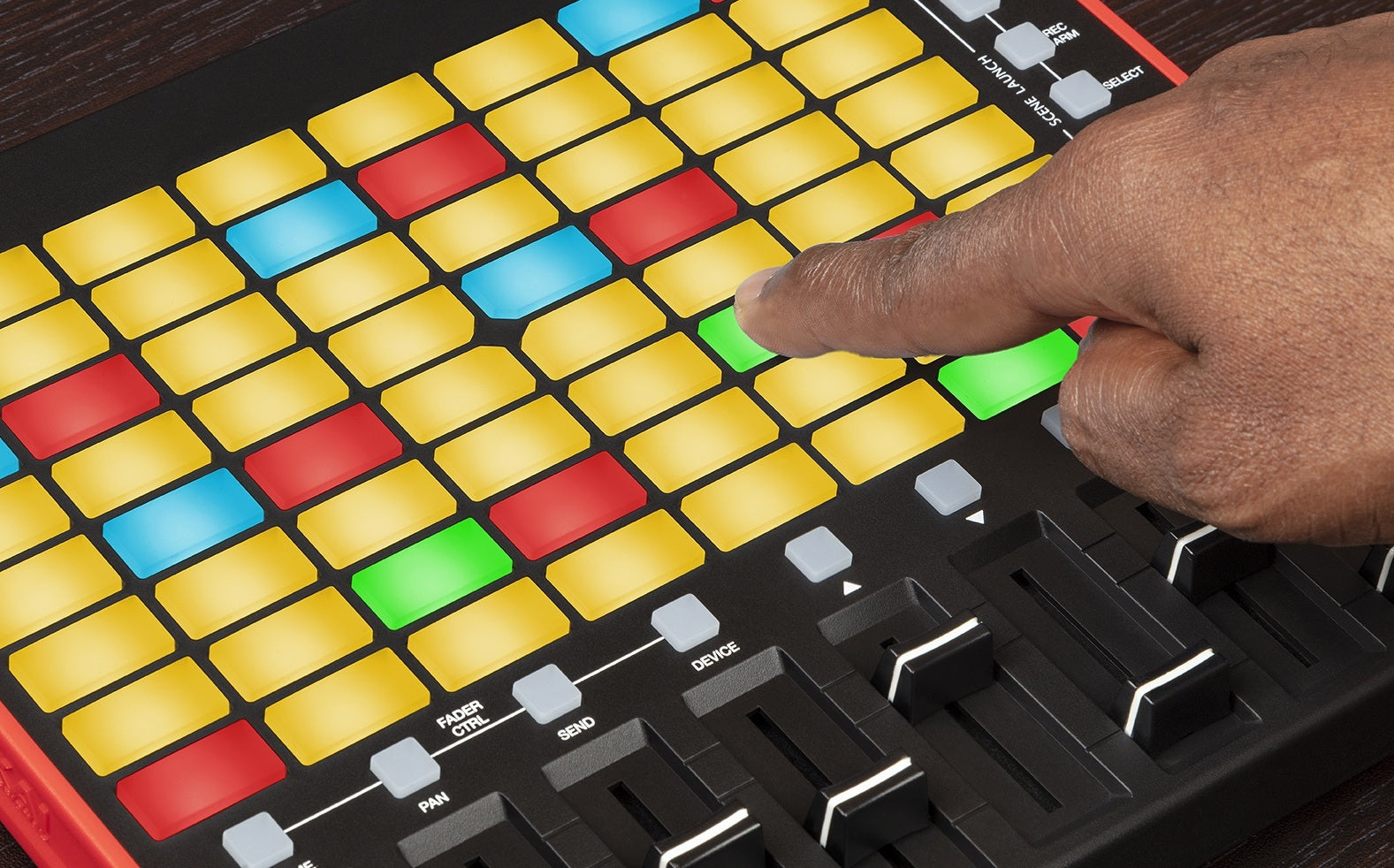 Akai Professional APC Mini MK2 MIDI controller with clip launching pads and hands pressing buttons on a compact interface.