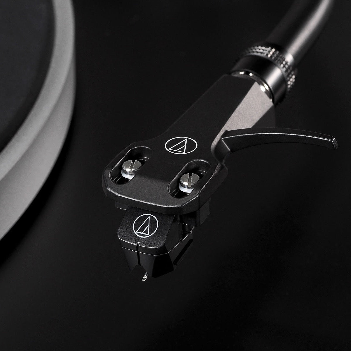 Audio Technica AT-LP5x turntable with sleek black design and tonearm, close-up view of the record player in detailed shot.