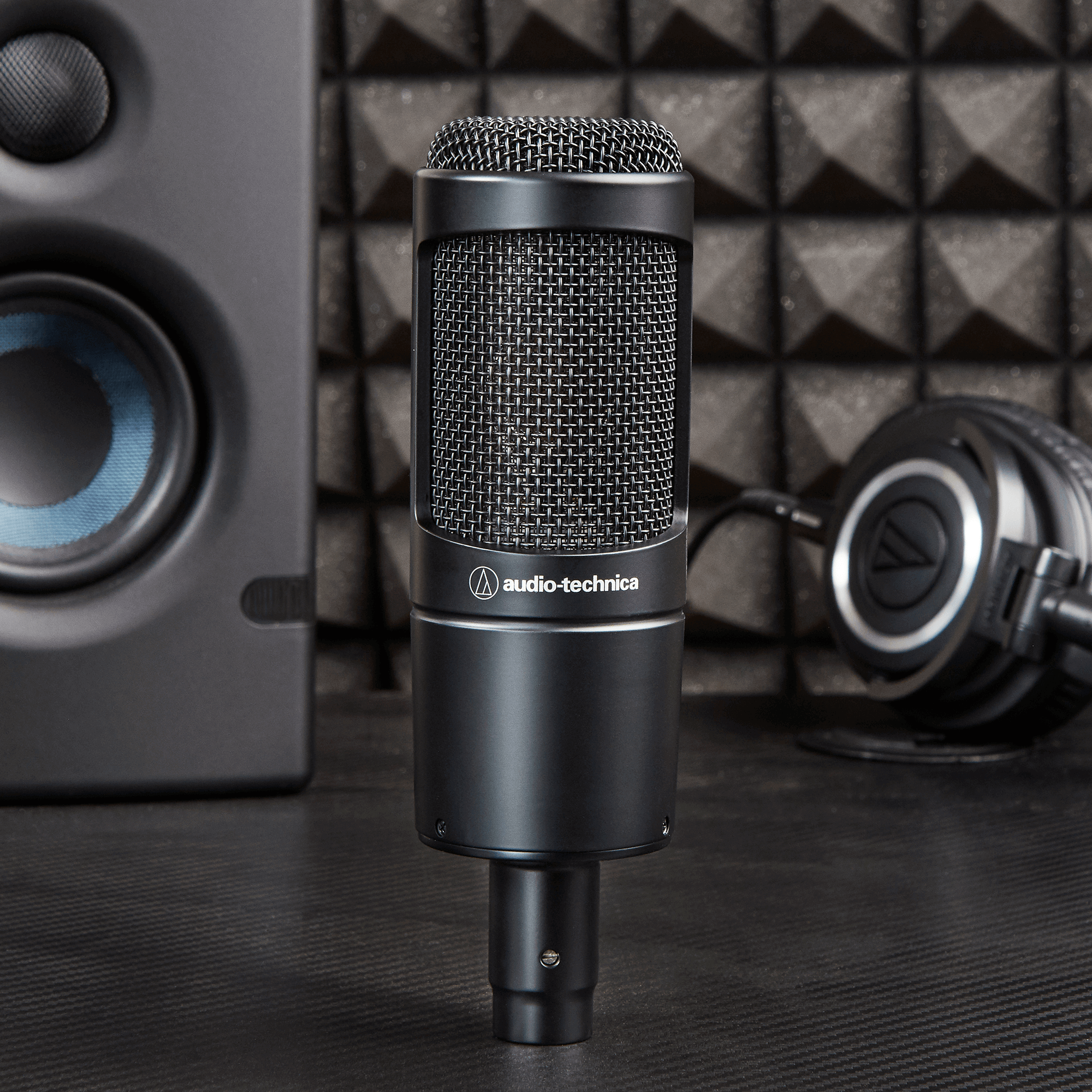 Audio Technica AT 2035 condenser microphone mounted on a stand with a pop filter, ready for studio recording or vocals.