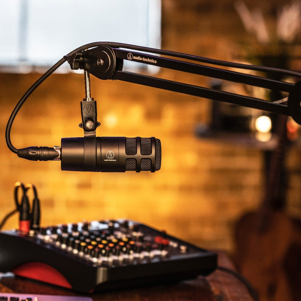 Audio Technica AT2040 dynamic microphone shown in a professional studio setup on a lifestyle background.