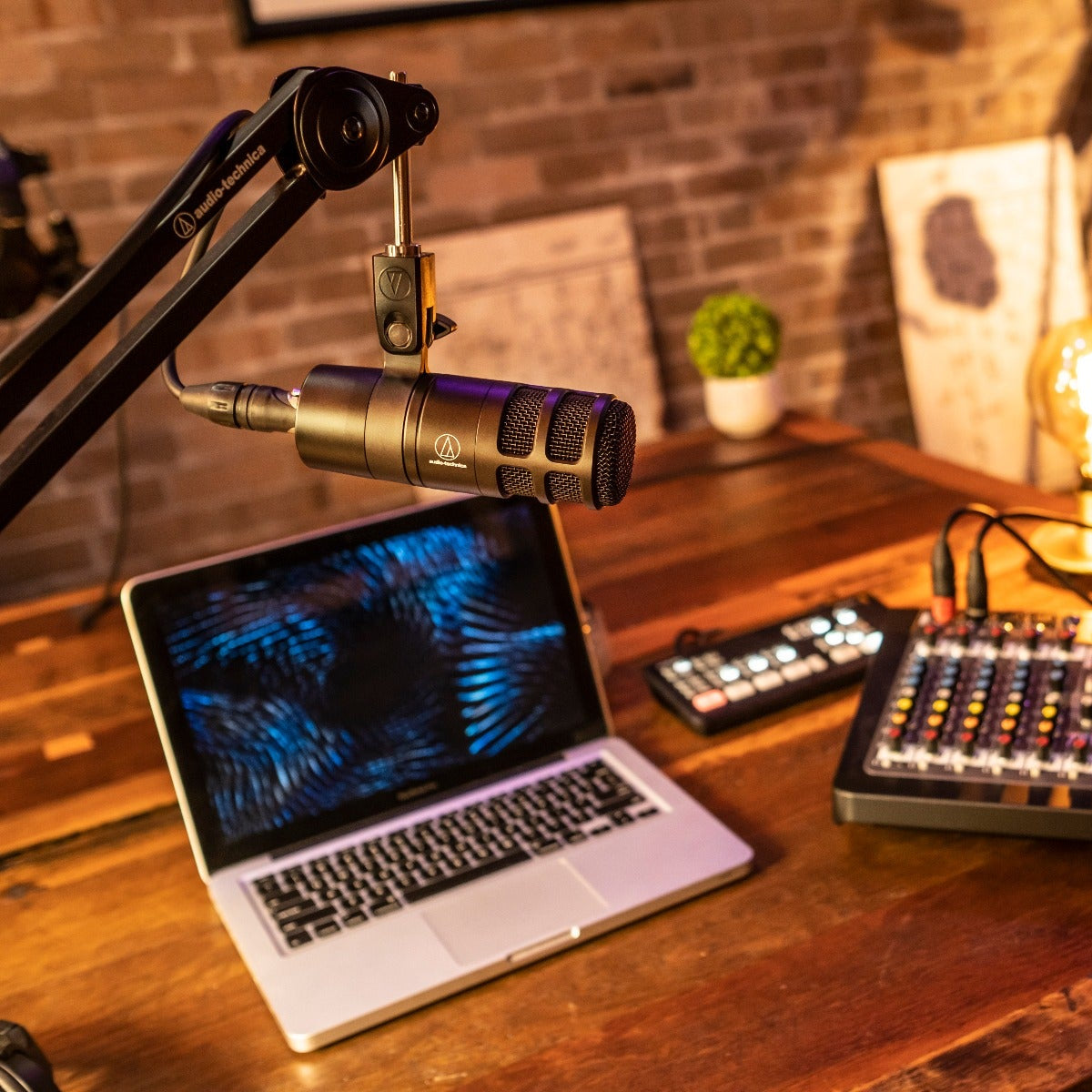 Audio Technica AT2040 dynamic microphone shown in a professional recording studio setting with microphone stand.