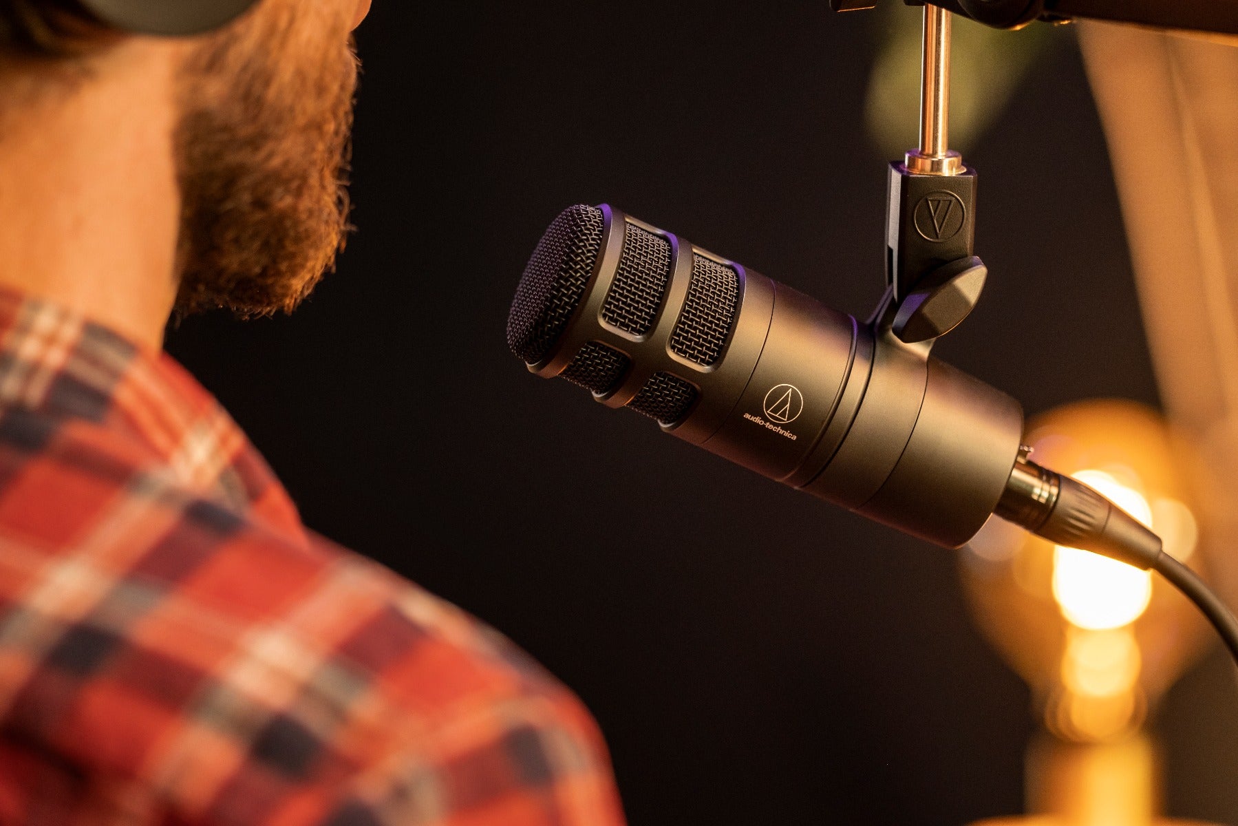 Audio Technica AT2040 dynamic microphone shown in a live recording setup with a professional audio environment.