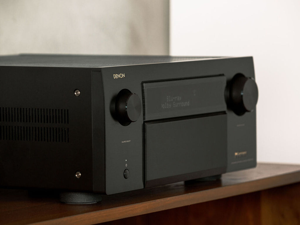 Denon AVC-A1H stereo amplifier with multiple audio input options and sleek design, shown on a modern home entertainment setup.