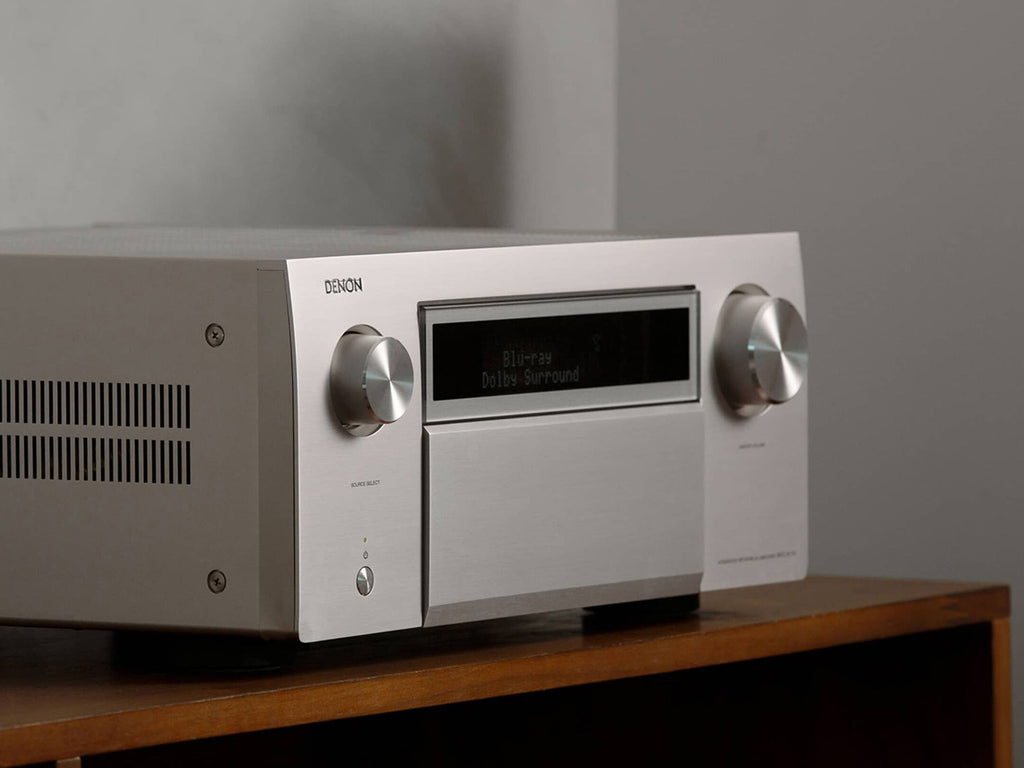 Close-up of Denon AVC-A1H silver stereo amplifier showing front panel controls and display.