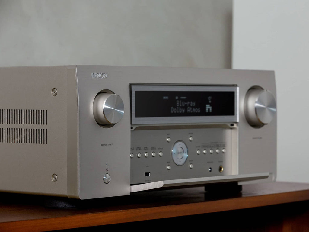 Close-up of the silver Denon AVC-A1H stereo amplifier showing front panel controls and display.