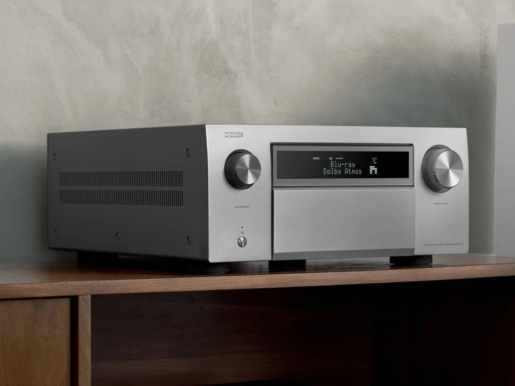Close-up of the silver Denon AVC-A1H stereo amplifier showing front panel controls and display.