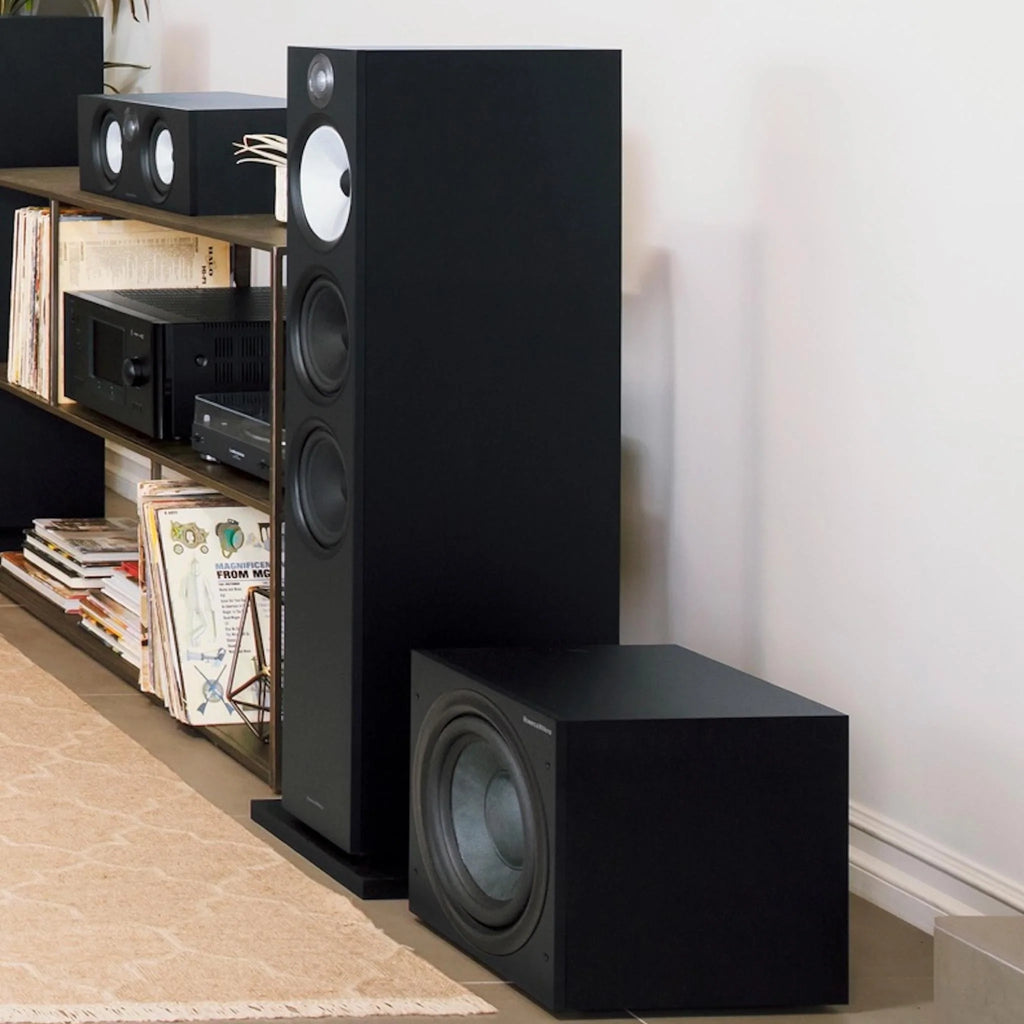 Bowers & Wilkins ASW608 matte black subwoofer with sleek design, shown in a lifestyle setup for home audio system.