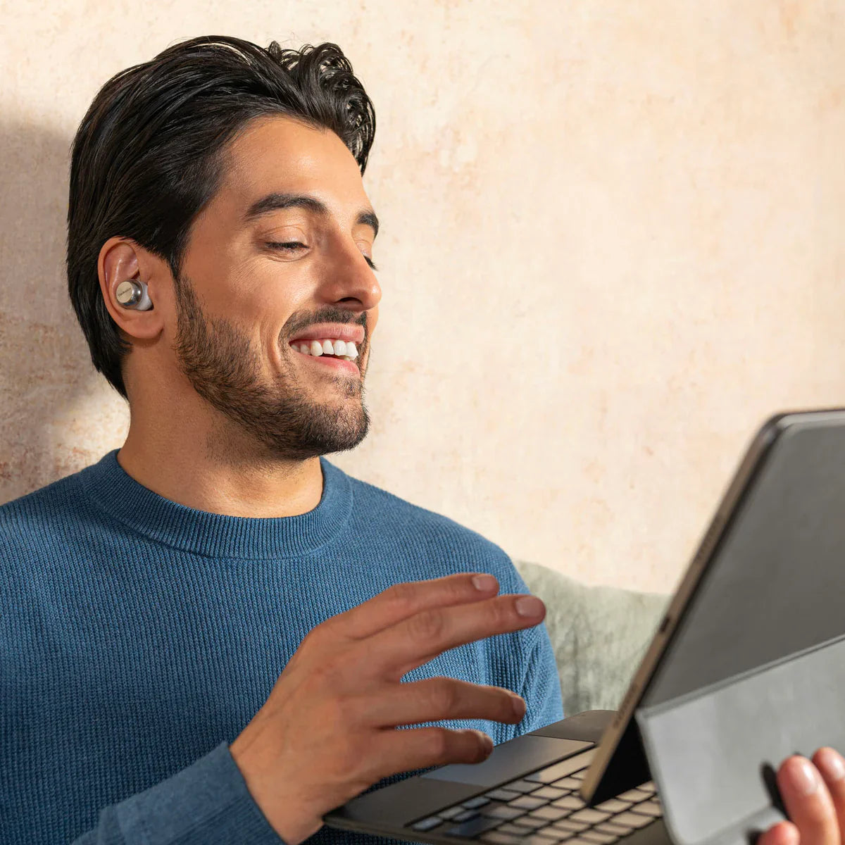 Technics EAH-AZ100 wireless in-ear headphones in silver, shown in a lifestyle setting with a modern, stylish background