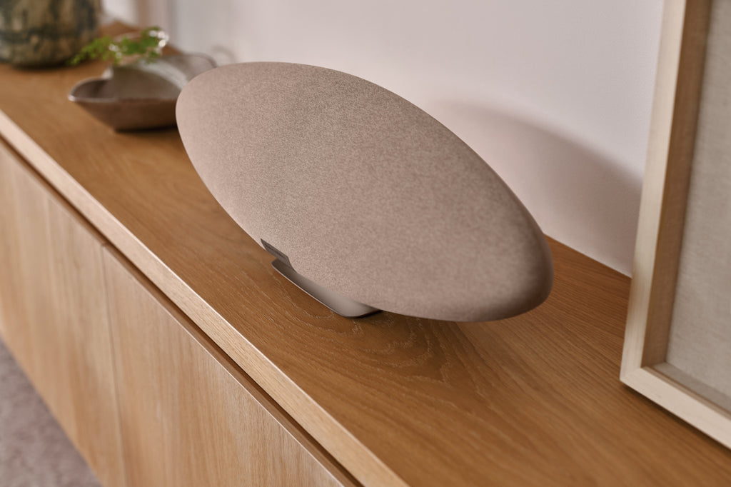 Bowers & Wilkins Zeppelin Pro Edition wireless speaker on a wooden surface, showcasing its sleek design and large speaker drivers.