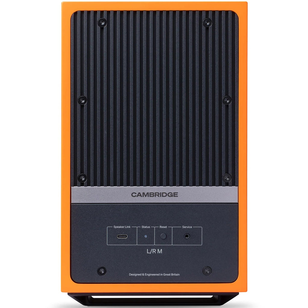Cambridge Audio L/R M active bookshelf speakers with orange finish, showing the sleek, compact design and front speaker grilles.