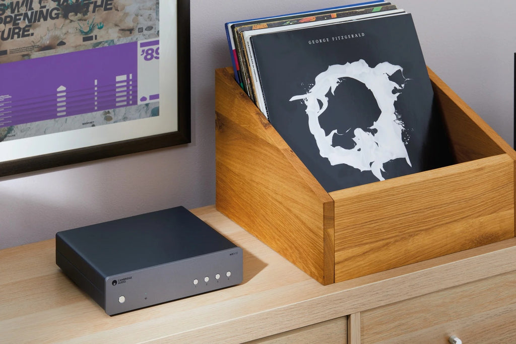 Cambridge Audio AXN10 music streamer setup next to a record player, showcasing modern audio streaming technology and sleek design.