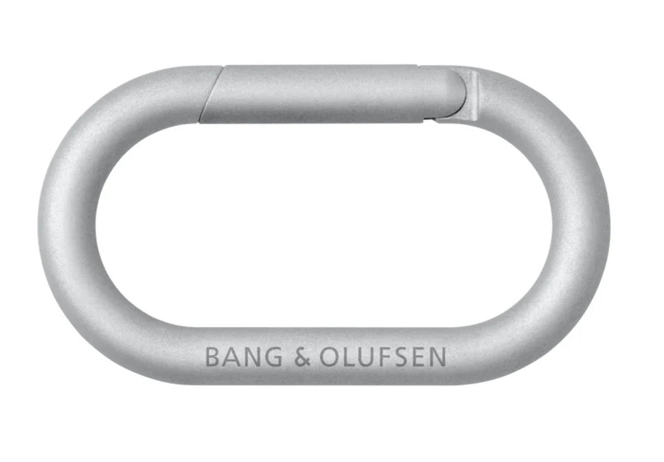 Bang & Olufsen Beosound Explore portable speaker with carabiner attachment, showcasing its rugged design and front control buttons.