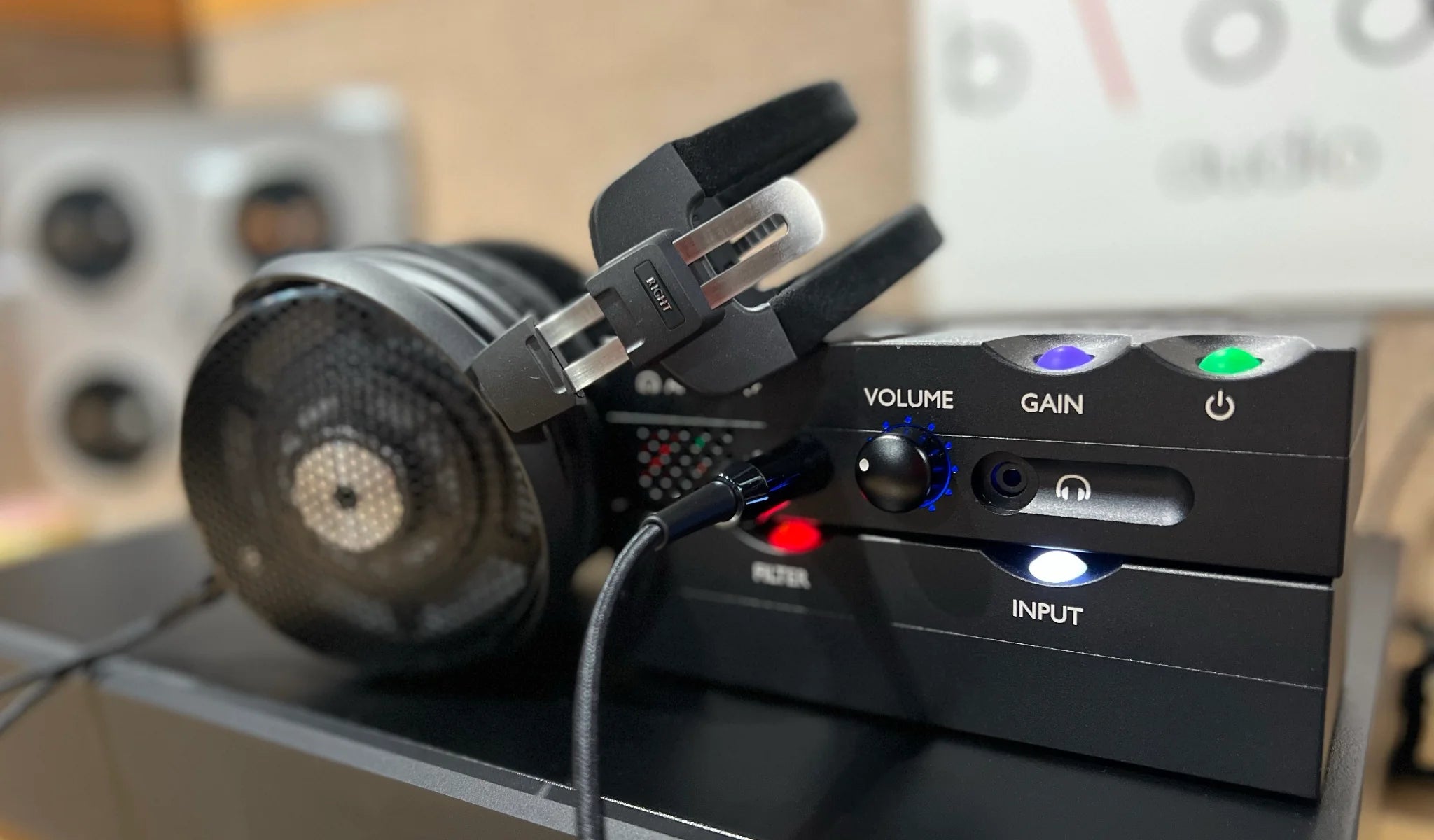 Chord Electronics Qutest headphone amplifier and DAC, sleek black device with LED display and connection ports on a modern desk setup.
