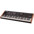 Sequential Prophet Rev2-16 synthesizer with 16-voice keyboard and control knobs, displayed on a music studio desk.