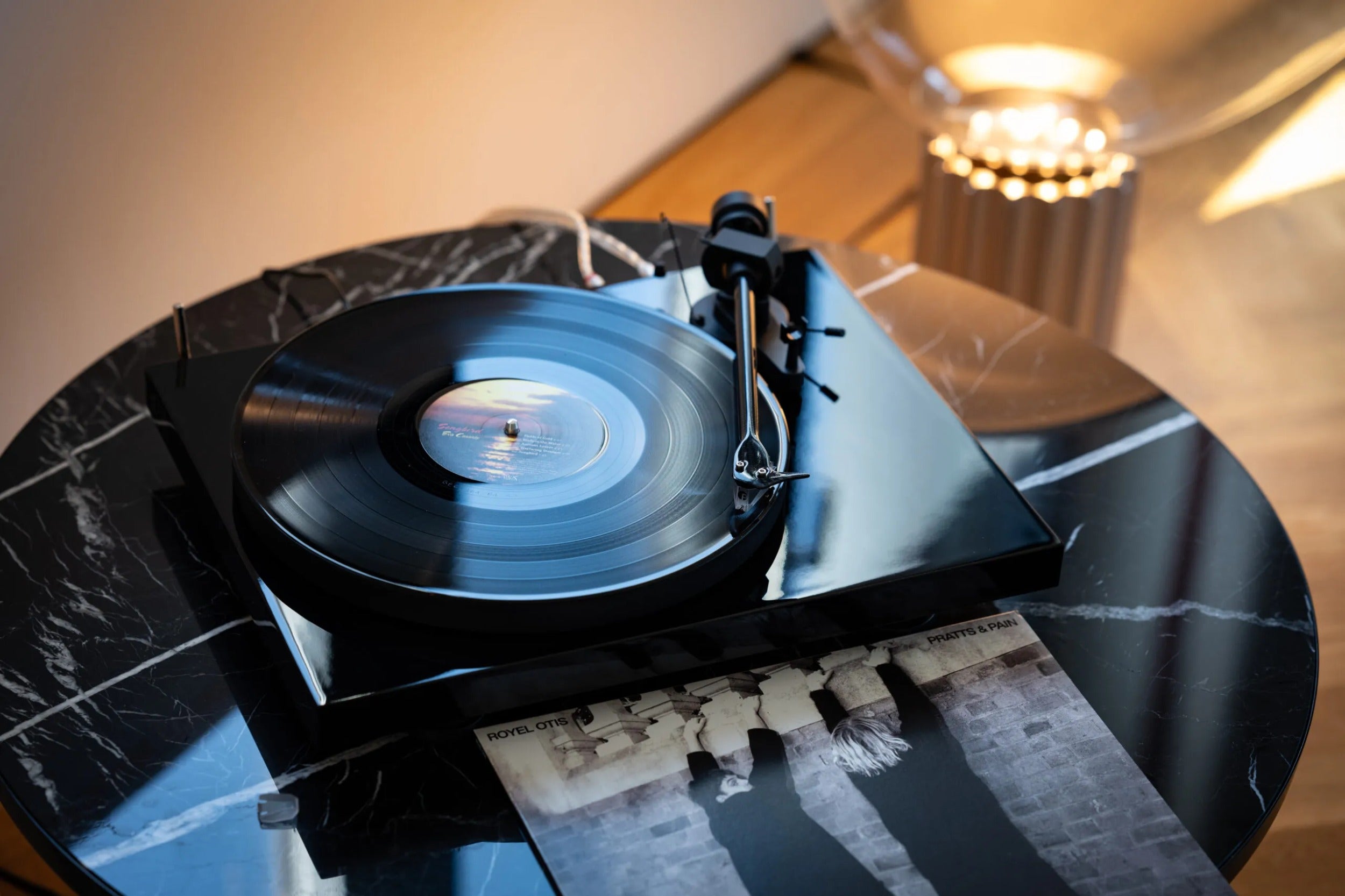 Pro-Ject Debut EVO 2 turntable with a sleek black finish, featuring a tonearm, platter, and modern design elements.