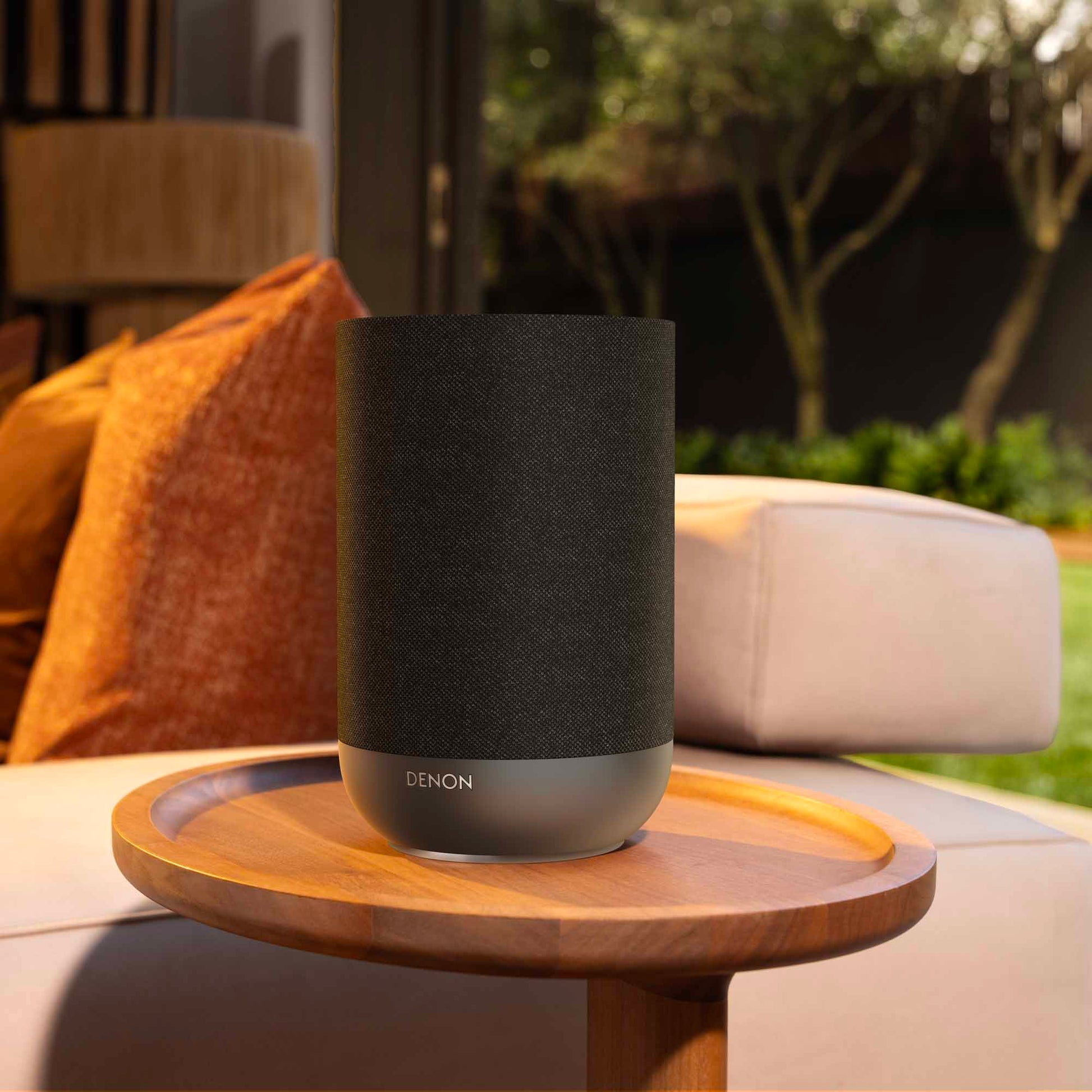Denon Home 200 wireless speaker in charcoal finish, compact design with fabric grille and control buttons visible.