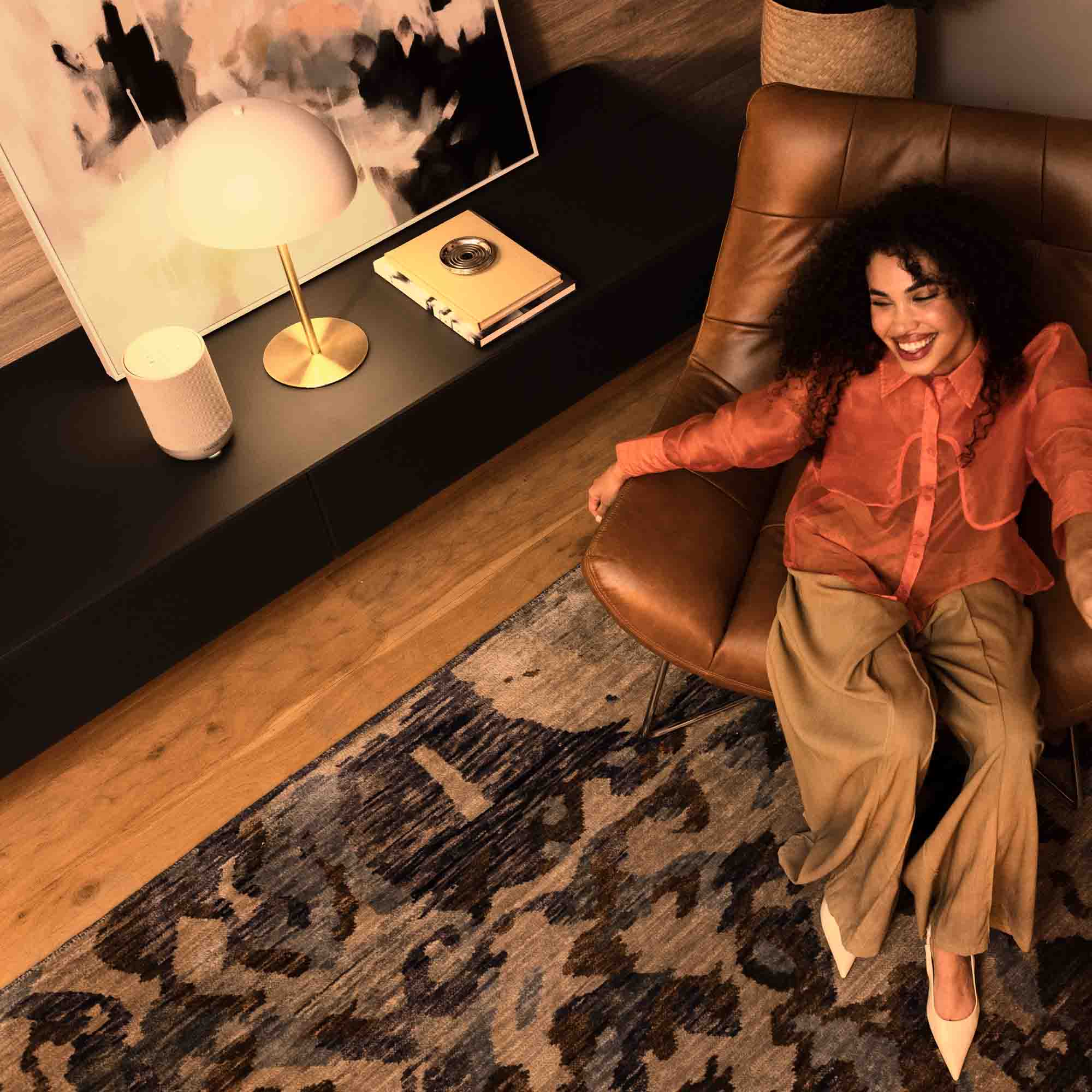 Denon Home 200 wireless speaker in stone color, compact design with fabric cover and control buttons on top.