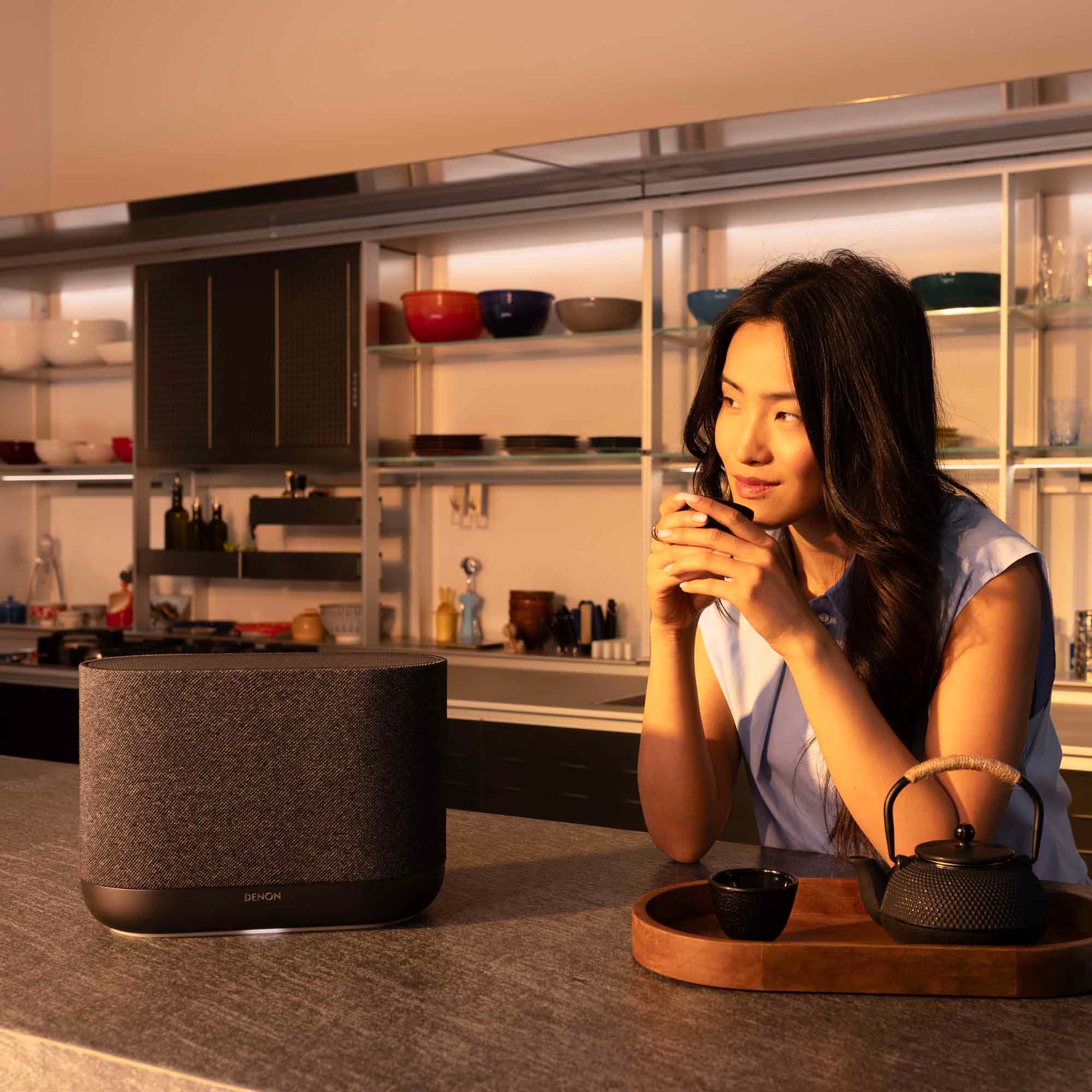 Denon Home 400 wireless speaker in charcoal finish, sleek modern design with fabric grille and control buttons on top.