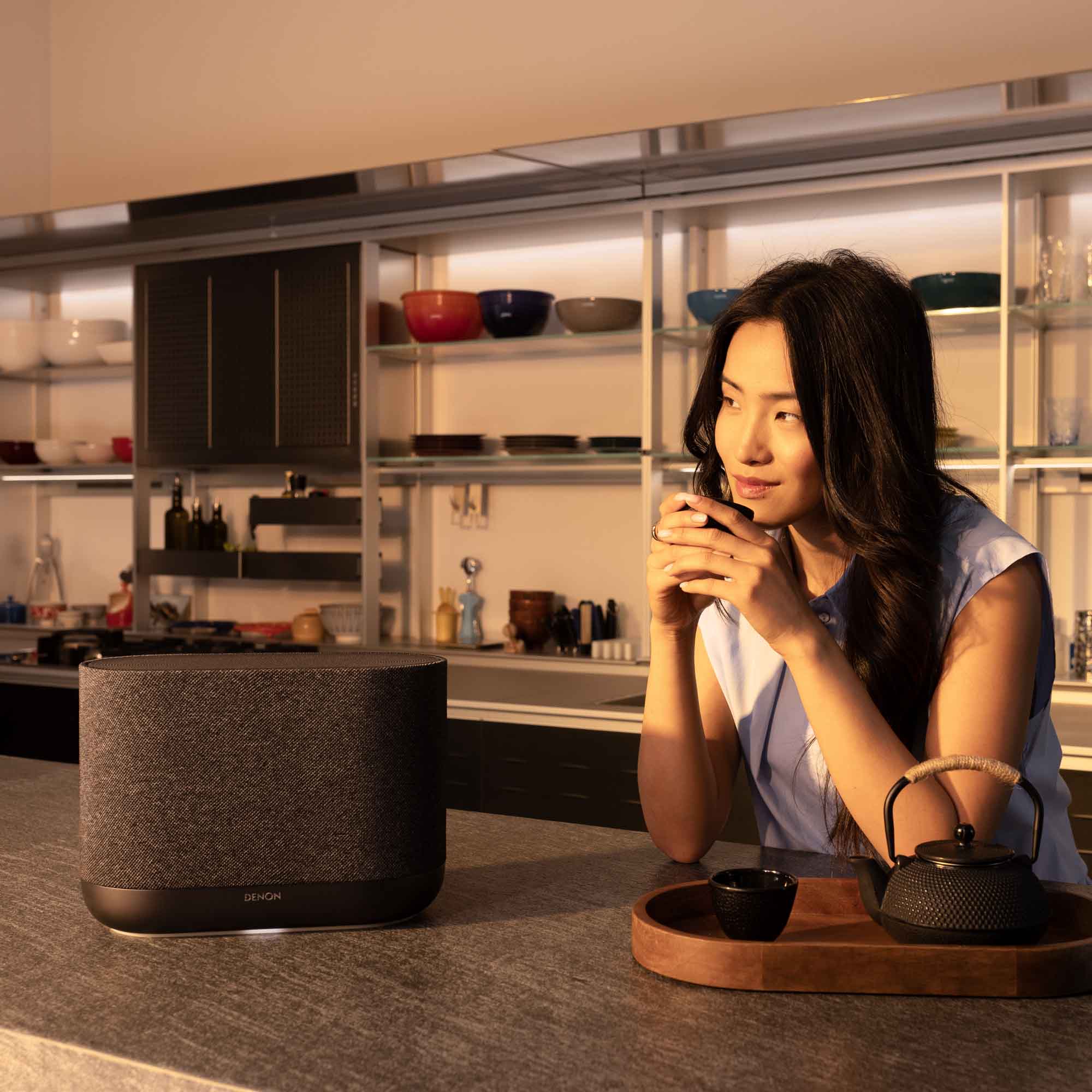 Denon Home 400 wireless speaker in charcoal finish, sleek modern design with fabric grille and control buttons on top.