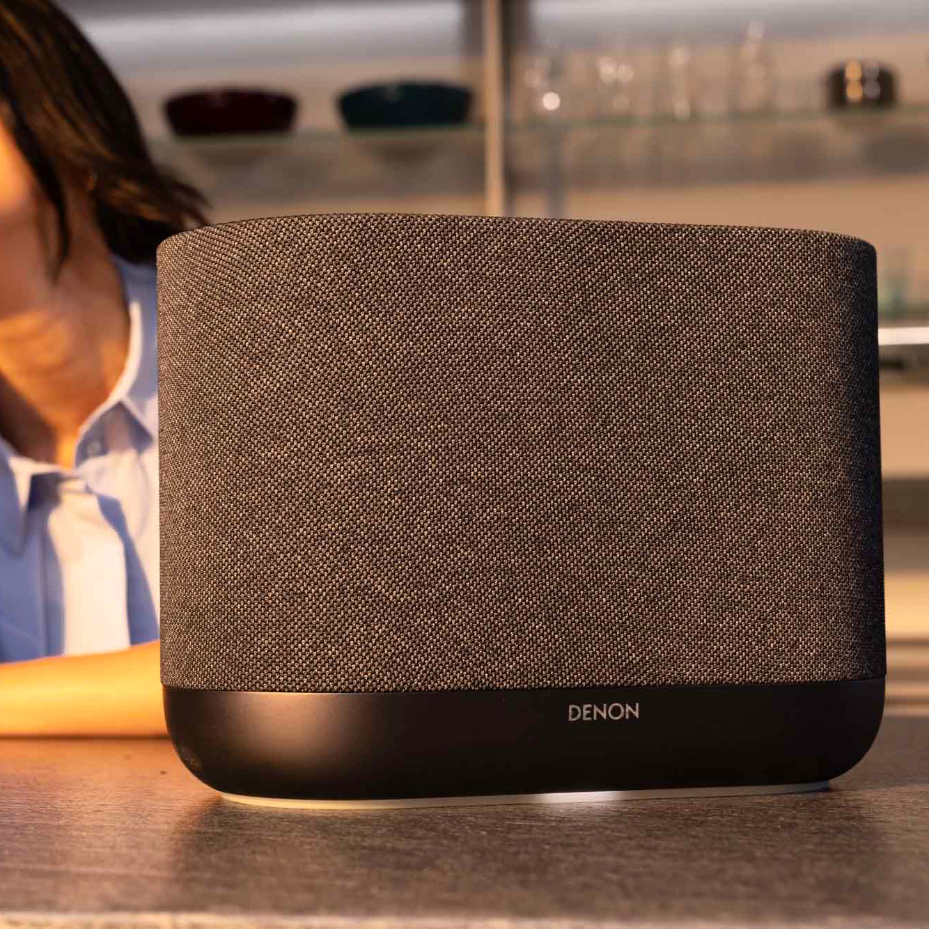 Denon Home 400 wireless speaker in charcoal color, sleek design with control buttons and fabric grille on front.