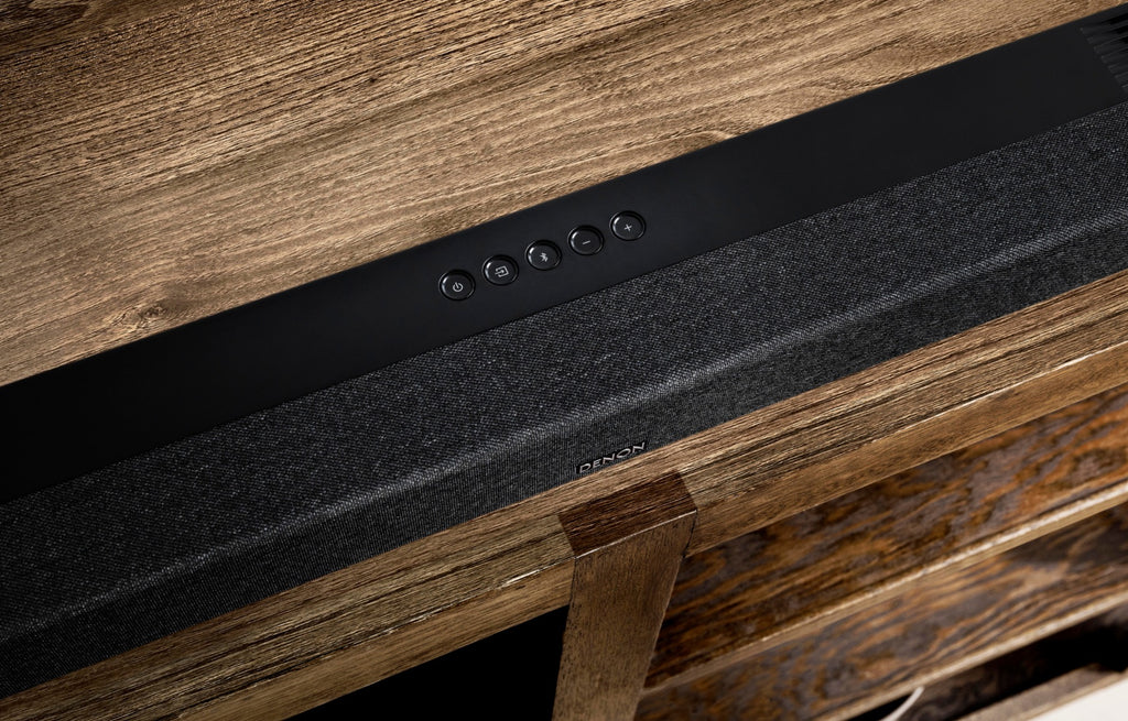 Denon DHT-S517 soundbar with sleek black design and remote control for enhanced TV audio and home entertainment.