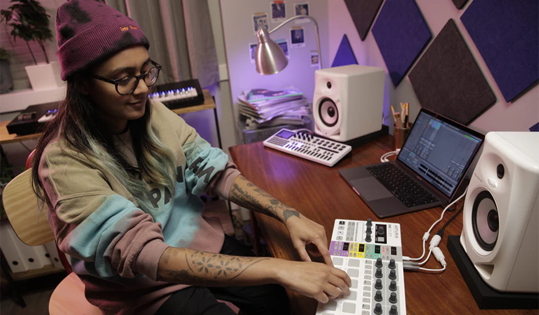 Pioneer DJ DM-50D-BT desktop speakers shown in a modern workspace setup with their sleek design and connectivity features.