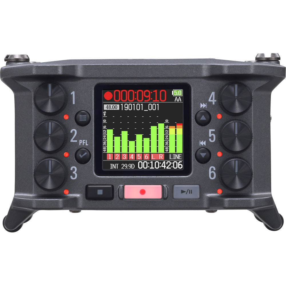 Zoom F6 digital recorder with multiple input ports and LCD display, shown on a table with accessories.