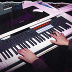 Novation FLkey 2 61 MIDI keyboard with illuminated pads and control knobs, shown in a music production setup.