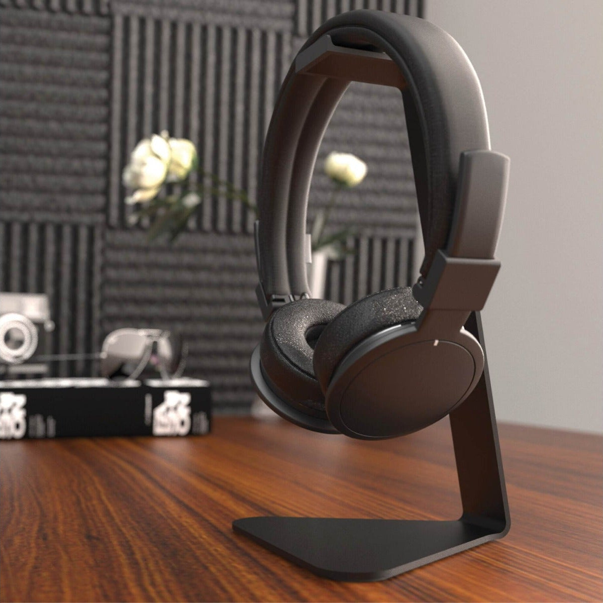 Kanto Audio H1 headphone stand in black with a sleek design, holding a pair of headphones on a flat surface.