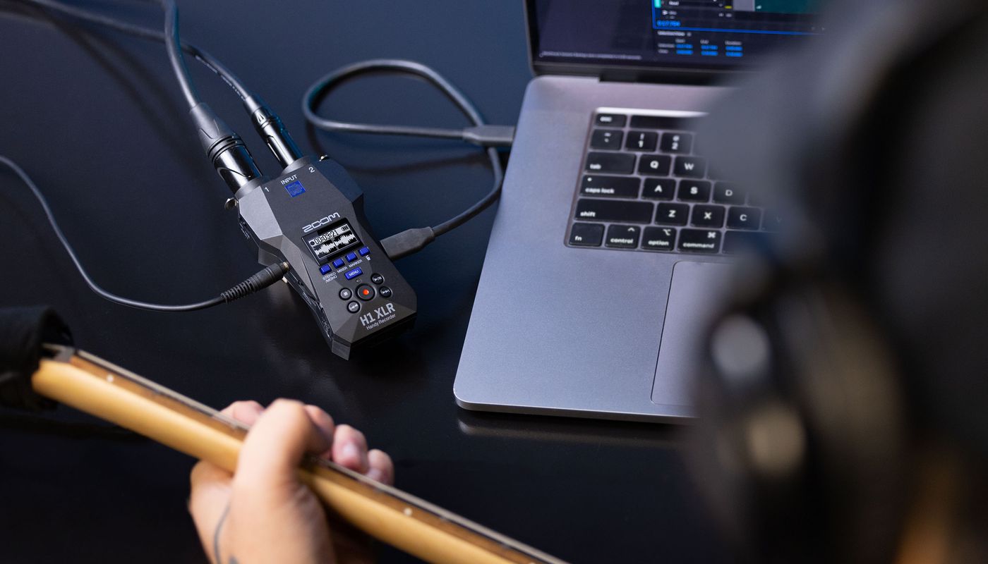 Zoom H1 XLR digital recorder with built-in microphones and XLR input, shown in a close-up view.